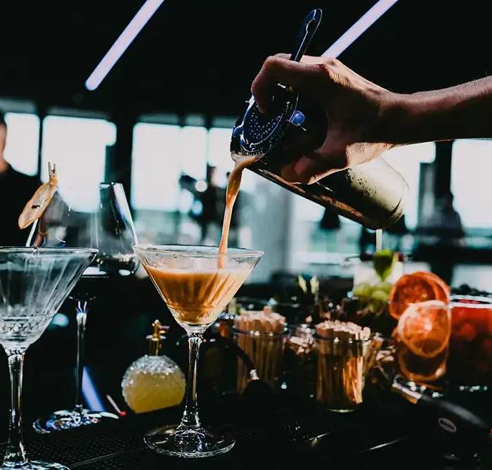 A bartender mixing a drink at a bar