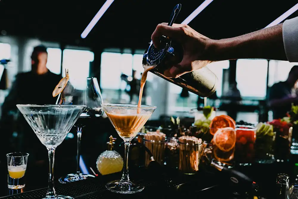 A bartender mixing a drink at a bar