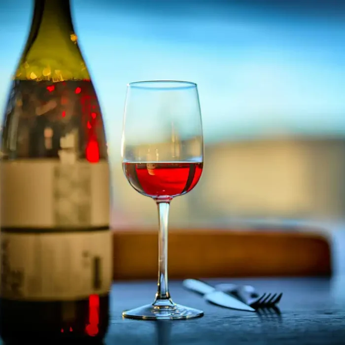 A wine bottle and a wine glass next to each other on a restaurant table